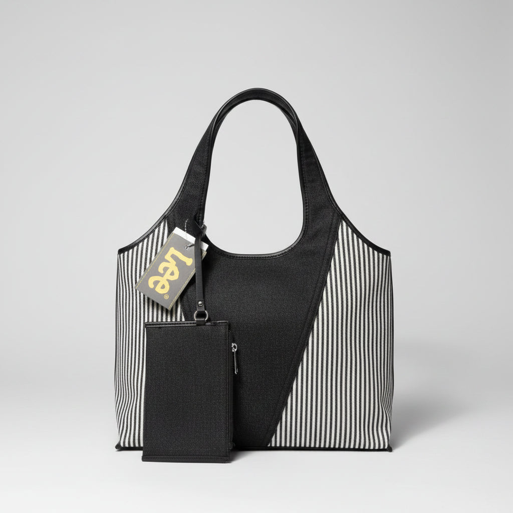 A Lee brand tote bag with a black and white striped woven body, black leather trim, and a black zippered pouch attached, resting on a textured surface with plastic bags in the background.